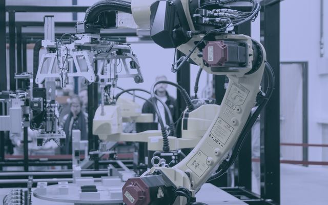 Ramię robota przemysłowego w zrobotyzowanym gnieździe produkcyjnym